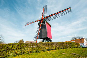Obraz premium Traditional red wooden windmill against blue sky