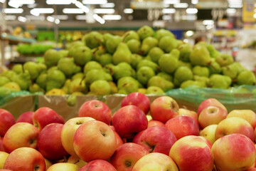 A pile of red apples lies in a drawer in a supermarket. A close-up red apples counter in a store waiting for buyers.