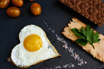 fried eggs with bread on a black background