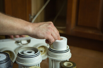 Changing filters in your home water purification system. The master puts clean filters in flasks...