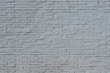 high wall of white bricks, with harsh midday light, and different reliefs