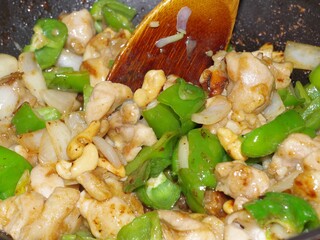 鶏肉とピーマンとカシューナッツの炒め物を作っているシーン