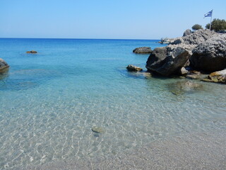 Obraz premium the tranquility and the crystal water of the paradisiac beach in Agios Nikolaos, Spoa, Karpathos, Greece