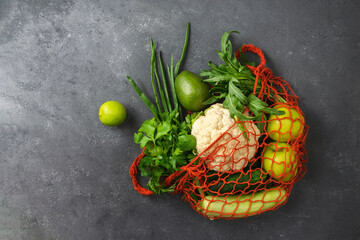Organic vegetables and fruits in a grocery bag on a black background with copy space. Concept of eco shopping.