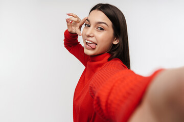 Photo of joyful woman gesturing peace sign while taking selfie photo