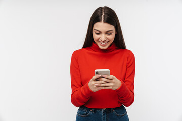Photo of happy caucasian young woman smiling while using mobile phone