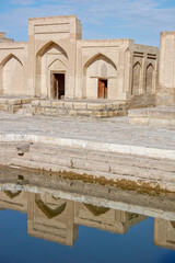 Obraz premium A madrassa near Samarkand, Uzbekistan, reflected in water.