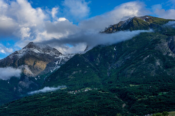 mountain panorama in spring with cloudy sky and play of light in the mountains