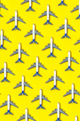 Pattern made of model airplane on yellow background.