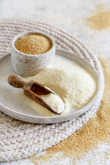 A Plate of raw Amaranth flour with a scoop and a bowl Amaranth seeds