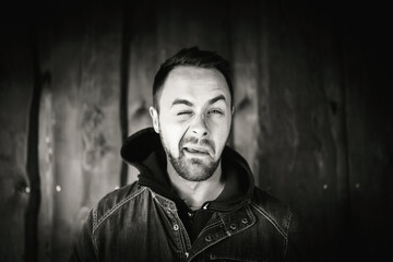 Obraz premium Młody człowiek przed drewnianą ścianą