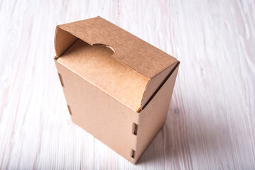 Cardboard box with cover on wooden background