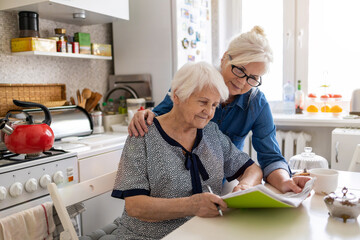 Rijpe vrouw helpt bejaarde moeder met papierwerk