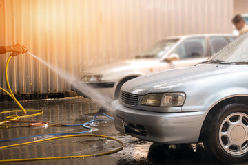 Car wash service by high pressure water spray with shiny effect.