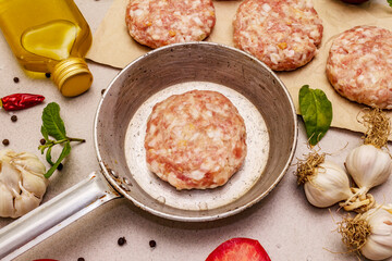 Raw cutlets, fresh vegetables, spices, olive oil. Vintage pan, picnic or barbecue cooking concept