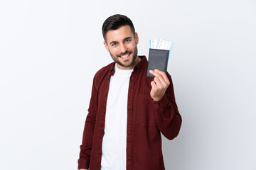 Young handsome man over isolated white background happy in vacation with passport and plane tickets