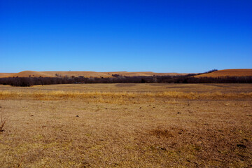 Fototapeta na wymiar Open prairie view with dry grass in the Flint Hills of Kansas on a sunny winter's day