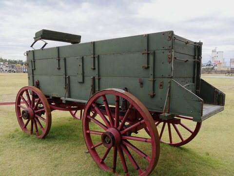 Vintage wagon with wheels painted in red and displayed outdoors in a park