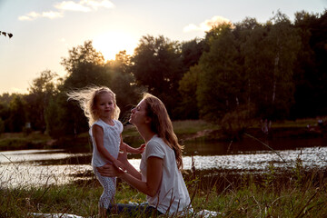 Fototapeta premium Daughter and mom are hands together. The family is happy. Smiles and laughter. They look at each other.