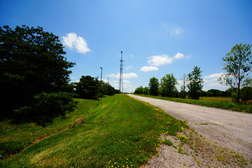 rural road in the countryside with a cell phone tower in the distance