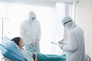 Disease treatment room for infected patient, infected patient woman lying in bed with doctor wearing protective clothing in quarantine at hospital, take care of the sick