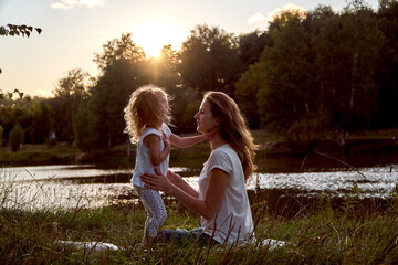 Daughter and mom are hands together. The family is happy. Smiles and laughter. They look at each other.