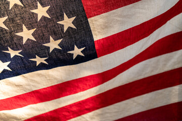 Close up of United of America flag in warm retro style and back light, selective focus