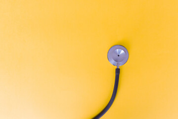 Top view of stethoscope on yellow background for coronavirus prevention. Covid-19 kit. Copy Space