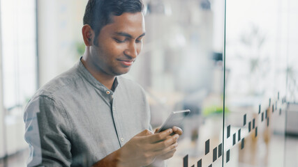 Portrait of Handsome Professional Indian Man Uses Mobile Phone, Writes Important Email. Successful...