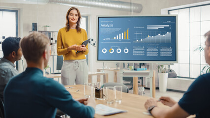 Female Chief Analyst Holds Meeting Presentation for a Team of Economists. She Shows Digital...