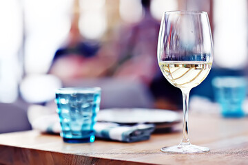 glass of white wine in the restaurant / white wine in the interior of the restaurant a table with glasses of wine, a romantic summer - obrazy, fototapety, plakaty