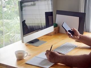 Fototapeta premium man's holding phone on desk at home.
