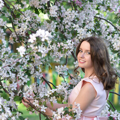 Girl in pink dress  with apple tree flowes