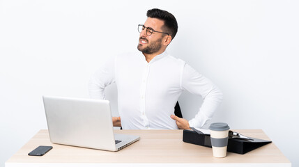Young businessman in a workplace suffering from backache for having made an effort