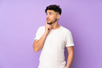 Obraz premium Arabian handsome man over isolated background thinking an idea while looking up