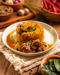Indian Mutton Biryani Dish served on wooden table. Typical food from India, made from goat meat mixed with spices and basmati rice