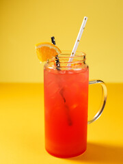 Hand squeezes an orange in a red cocktail