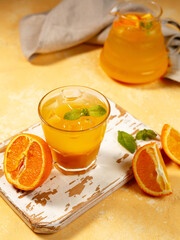 Fototapeta na wymiar orange juice with glassware on a wooden background with slices of orange