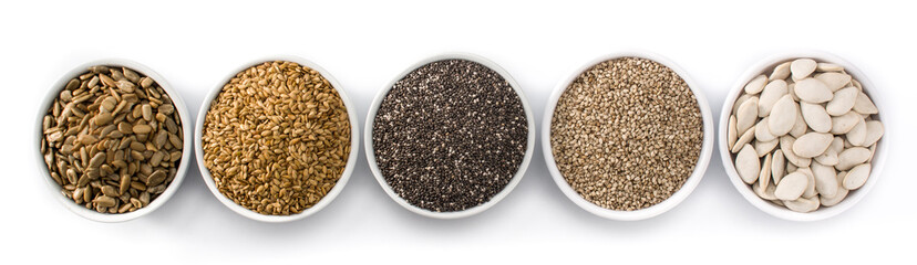 Assortment of different seeds in bowl isolated on white background. Pumpkin, linen, chia, sunflower, and sesame seeds. Panorama view