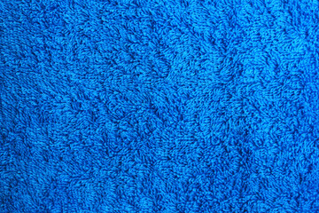 Fototapeta na wymiar Fluffy texture of bath paper terry towel or carpet background. Blue woven terrycloth tissue material design. Soft wool pattern, cozy bath item for hygiene close up detailed view