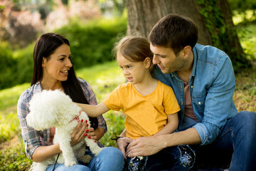 Happy family with cute bichon dog in the park