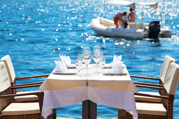 Elegant restaurant table waiting for customers by the sea; outdoor terrace in Perast, Montenegro