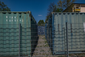 Container hinter einem Metallzaun