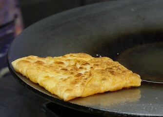 Close up shot of an omelet fried on a hot grill and ready to eat at the street food market in Chiang Mai, Thailand