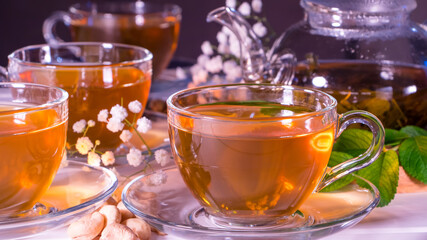 Teapot and mugs with green tea, cashew nuts, green leaves and white gypsophila flowers.Tea ceremony, traditional drink. Afternoon tea, homelike. Oriental, cozy, preparation, japanese, leafy, herbal