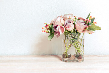 Pink roses in a vase on a table with copy space