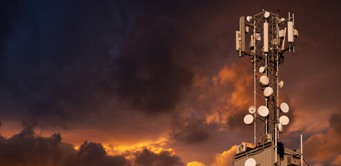 5G network transmitters on the roof of a skyscraper on a background of dramatic sky.