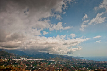 Fototapeta premium Storm clouds surrounding Nerja and The Moorish village of Frigiliana nestling in the mountains, Costa del Sol, Andalucia, Spain