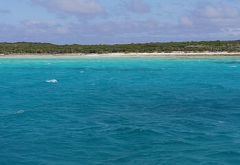 Different hues of blue waters with a beautiful island in the islands of the Exuma Cays, Bahamas.