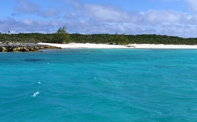 Beautiful stretch of white sand beaches in the islands of the Exuma Cays with its blue waters and blue skies above in the Bahamas.